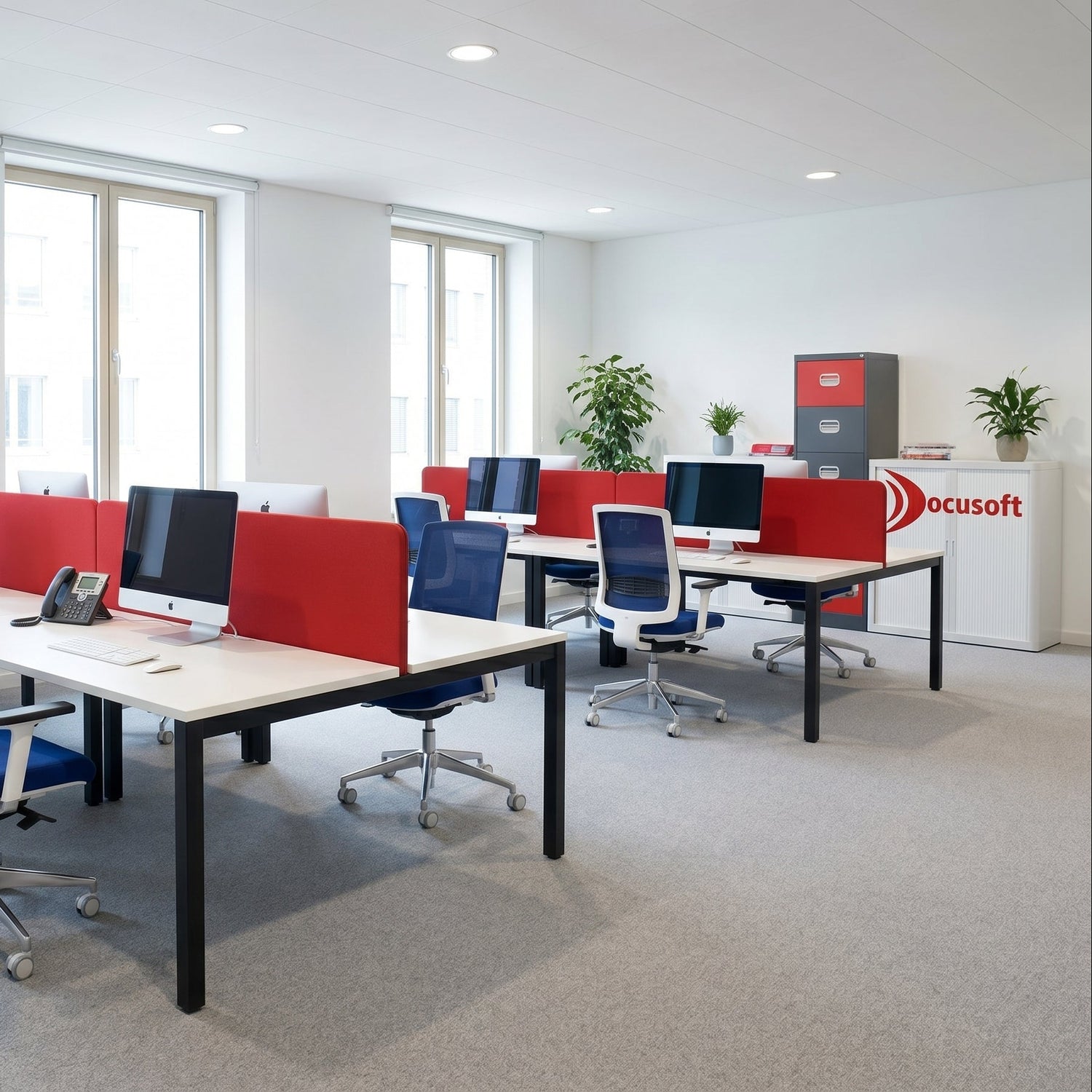 Modern office setup with red partition walls, white desks, and blue chairs.