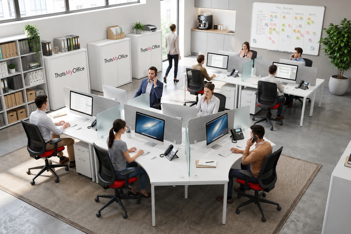 A bright, modern open-plan office with multiple white desks, office chairs, computer monitors, shelving, and a whiteboard. Several people are seated at the desks working, and one person stands near the back.