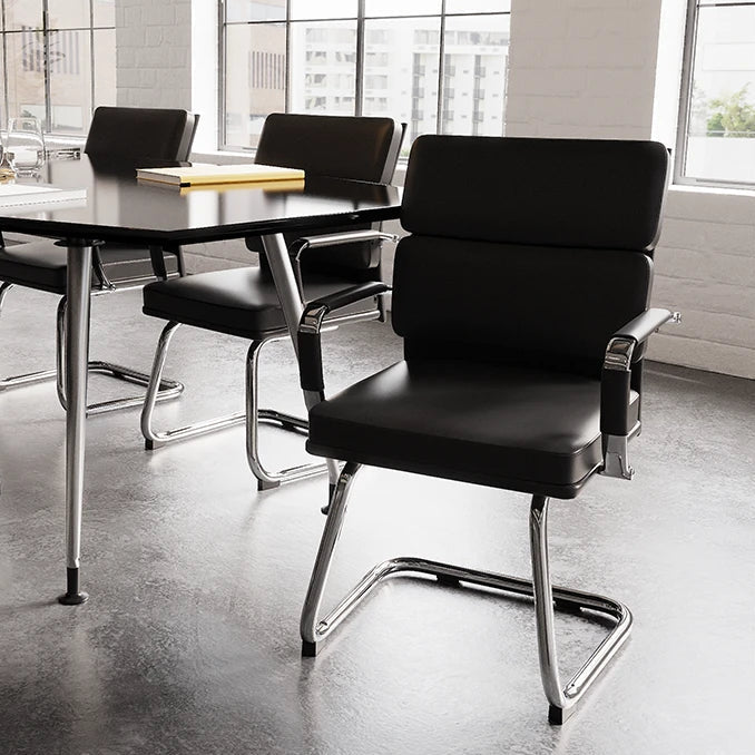 Modern conference room with black chairs and table near large windows.