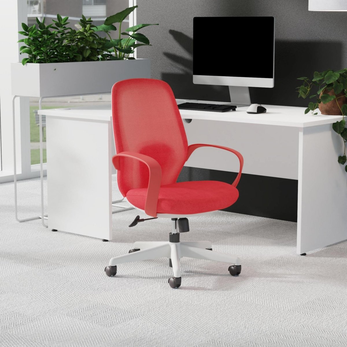 Red office chair in front of a white desk with a computer setup.