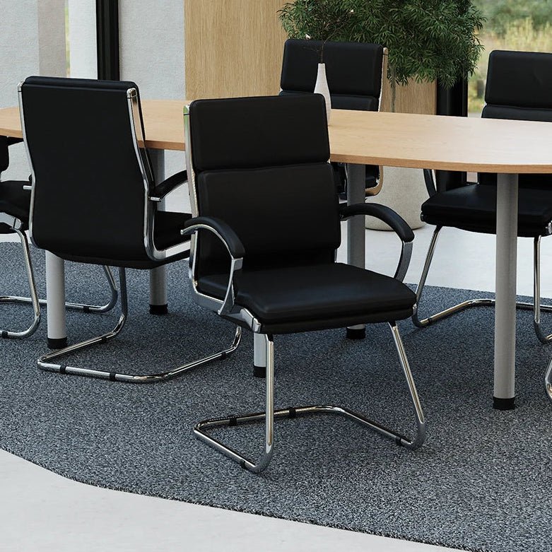 Modern conference room with black chairs and a round wooden table.
