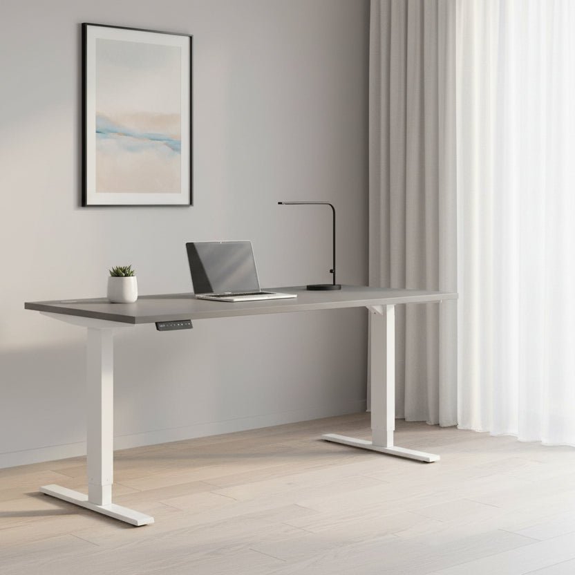 A modern height-adjustable standing desk with a dark gray rectangular top and white metal legs, shown against a plain white background.