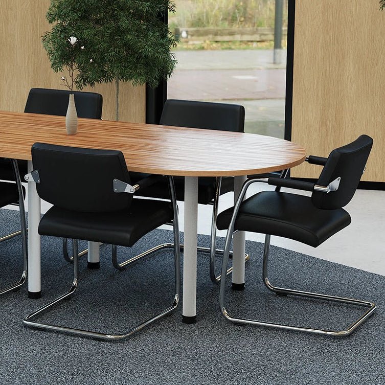 Modern conference room with a wooden table and black chairs, featuring large windows.