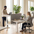 Two-person sit-stand height adjustable desk in office
