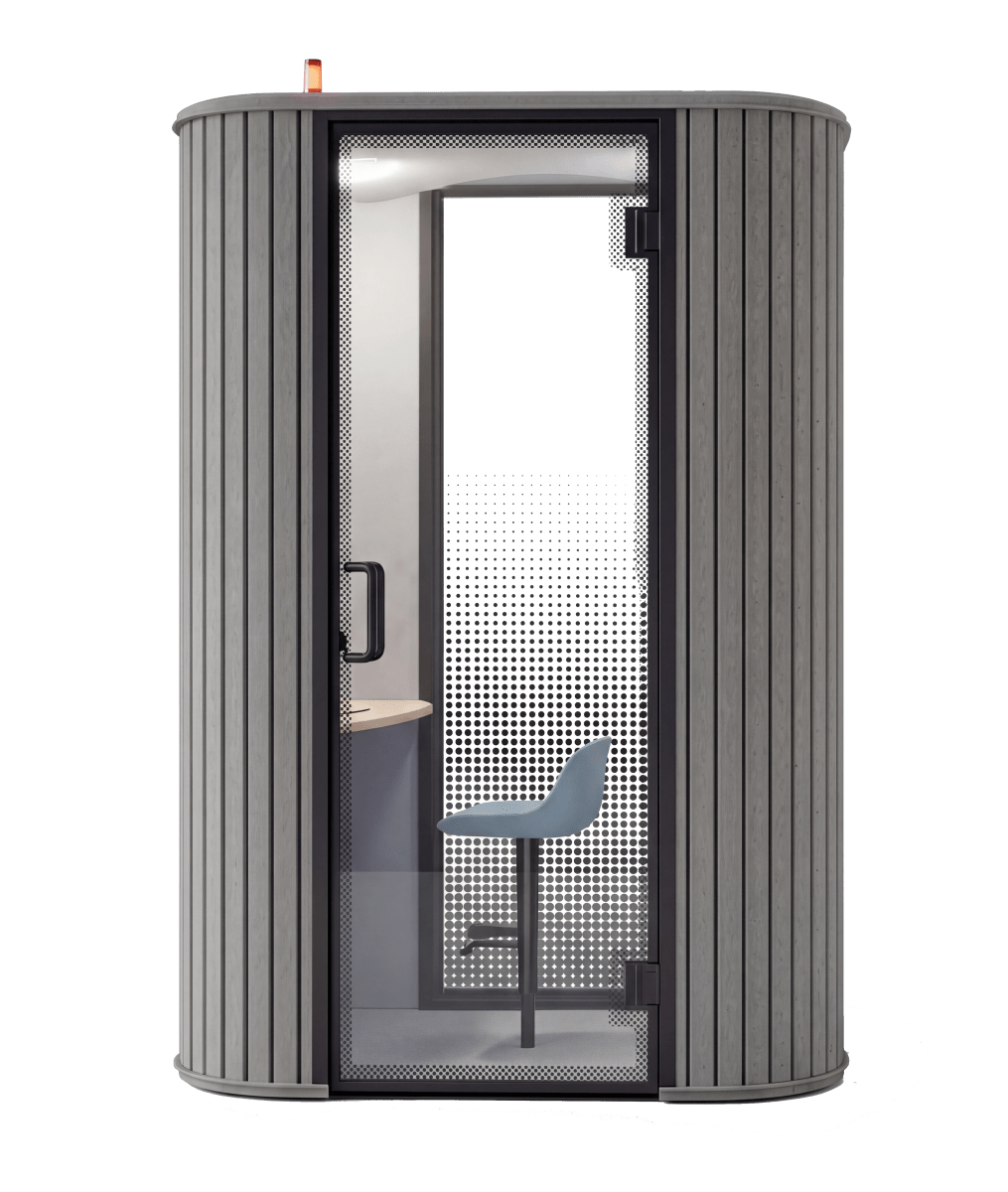 A modern, compact privacy pod phone booth with gray ribbed exterior walls, a black-framed glass door, and a visible interior featuring a light blue chair and desk area, shown on a plain white background.