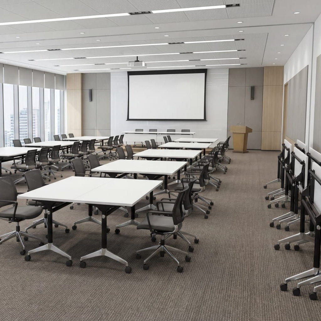 Modern conference room with tables, chairs, and a large screen on a white wall.
