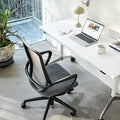 Modern office setup with a desk, chair, and laptop in a bright room.