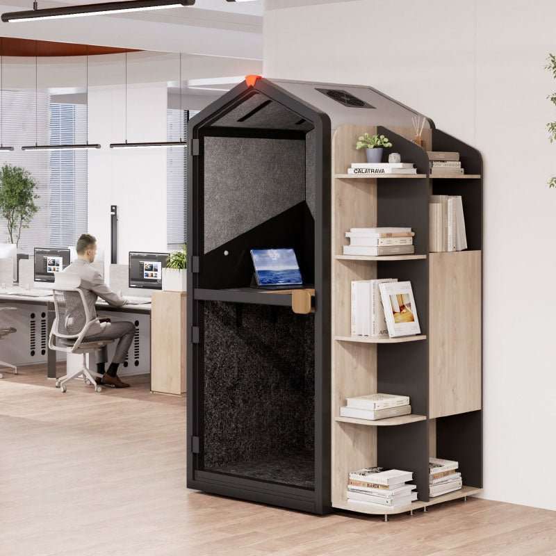 Modern office setup with a privacy pod and a person working at a desk.