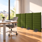 A set of four green upholstered office partition panels with dark metal feet, arranged in a modern office space next to a desk and chair.