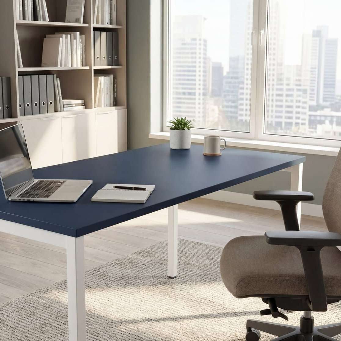 Modern office desk with a laptop, chair, and bookshelves in a bright room.