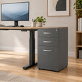 A three-drawer gray filing cabinet with silver metal handles, shown from a three-quarter angle on a clean white background.