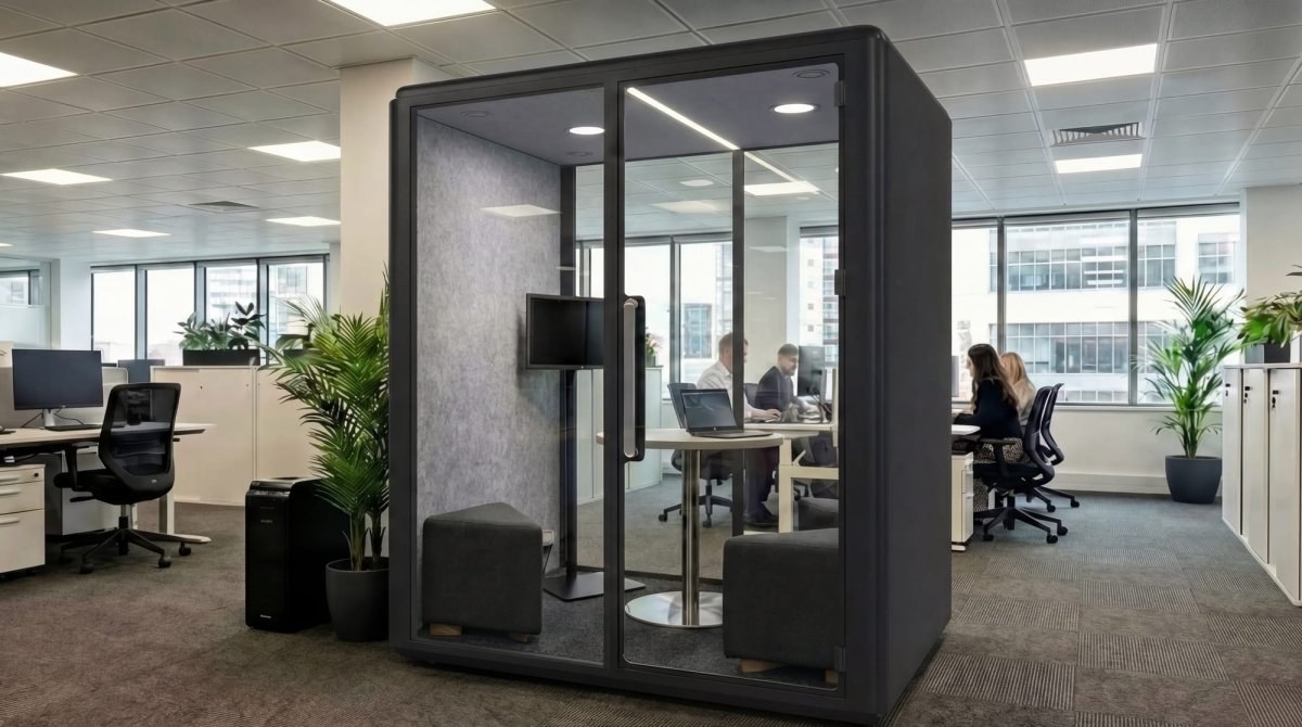 Modern office with a glass partitioned office pod and people working in the background.