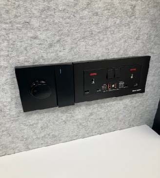 Black electrical panel on a gray wall