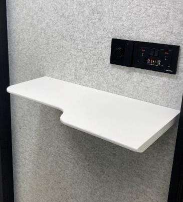 White shelf mounted on a gray wall with control panel above